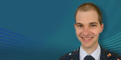 Andrew Pfeiffer wearing a Pac-Man jacket and tie
