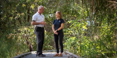 Two staff members in garden talking to each other 